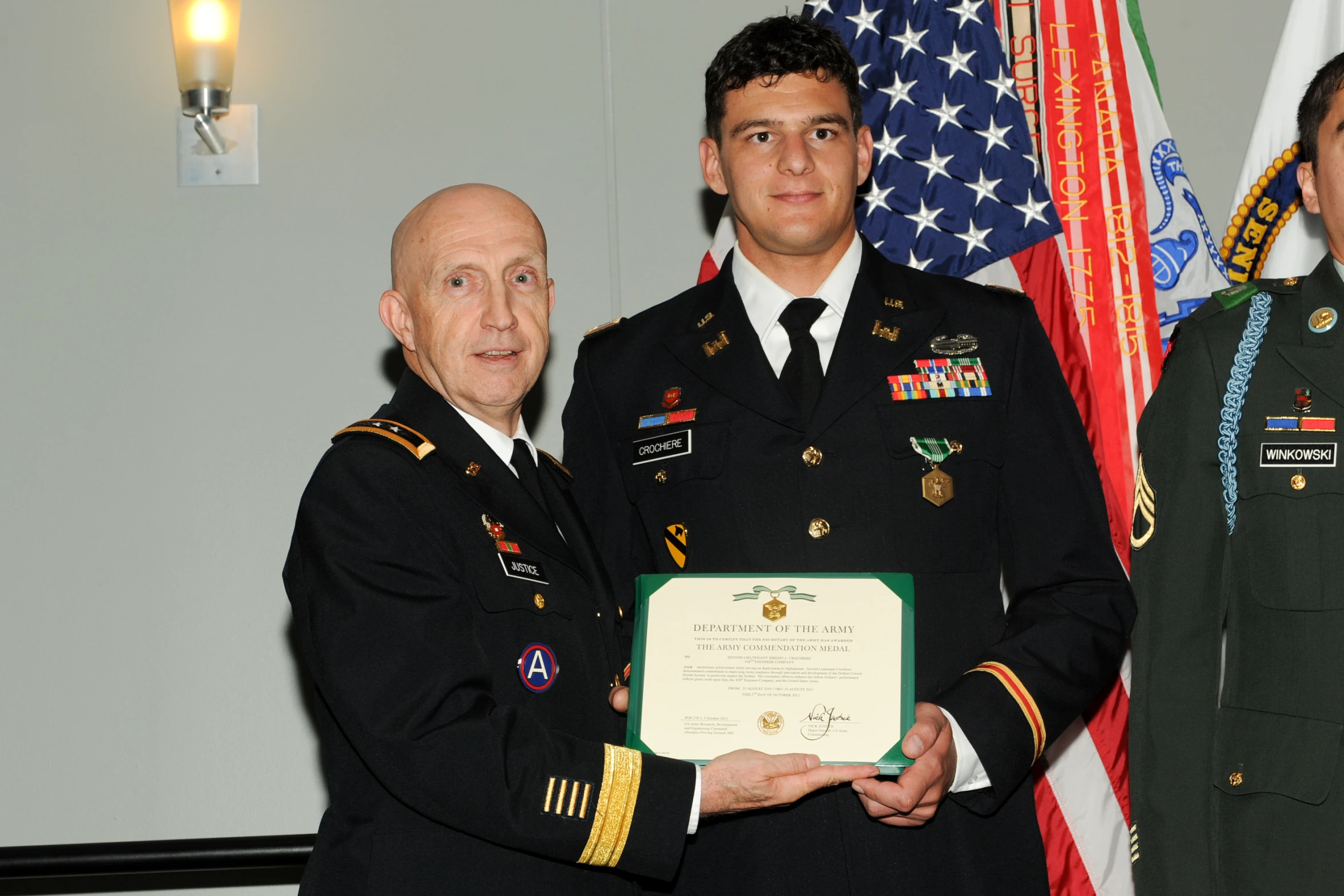 two men in uniforms holding an award plaque