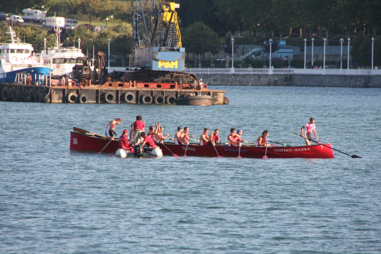 a row boat filled with people riding on top of water