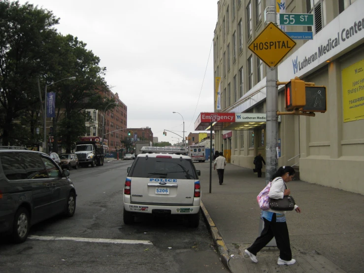 a woman walking down the street as others cross