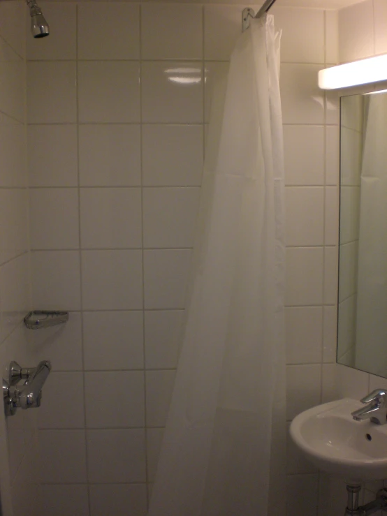 a bathroom with white tiled walls and a shower