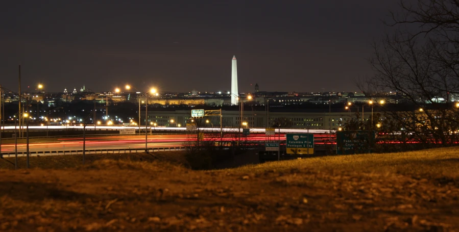 a highway runs through a night scene with a distant skyline