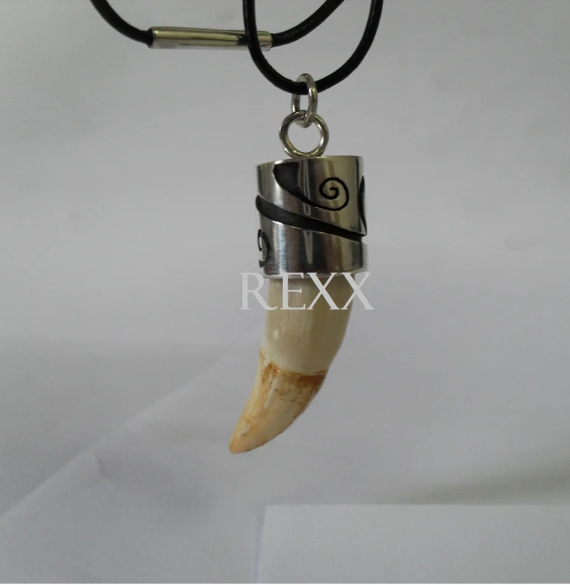 a skull shaped necklace with a silver and black cord is hanging from a cord