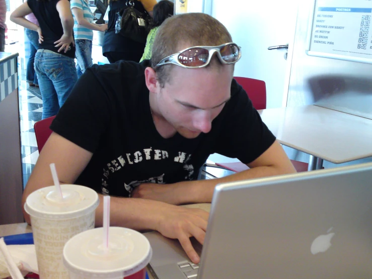 man at a computer with two drinks in front of him