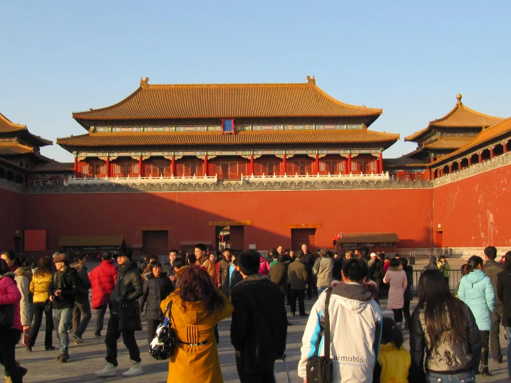 a large crowd of people are walking around an asian building