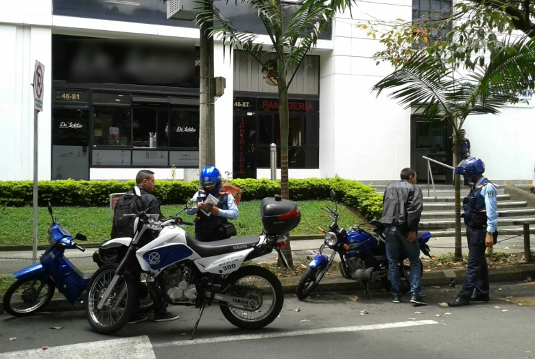 a group of people standing by some parked motorcycles