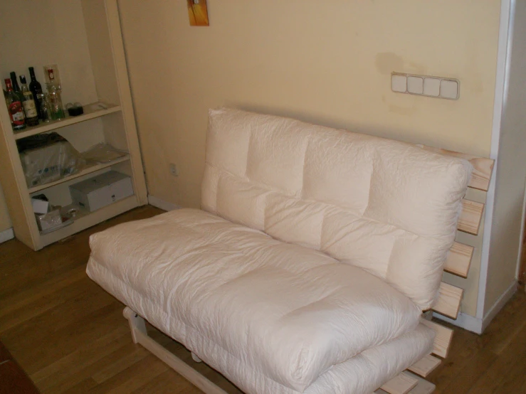 a couch with a pillow on top sitting under a cabinet