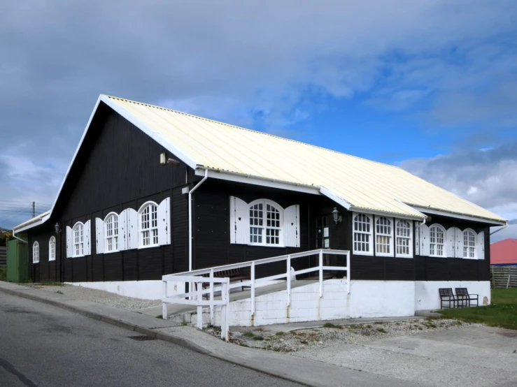 an old wooden house with white trim and doors