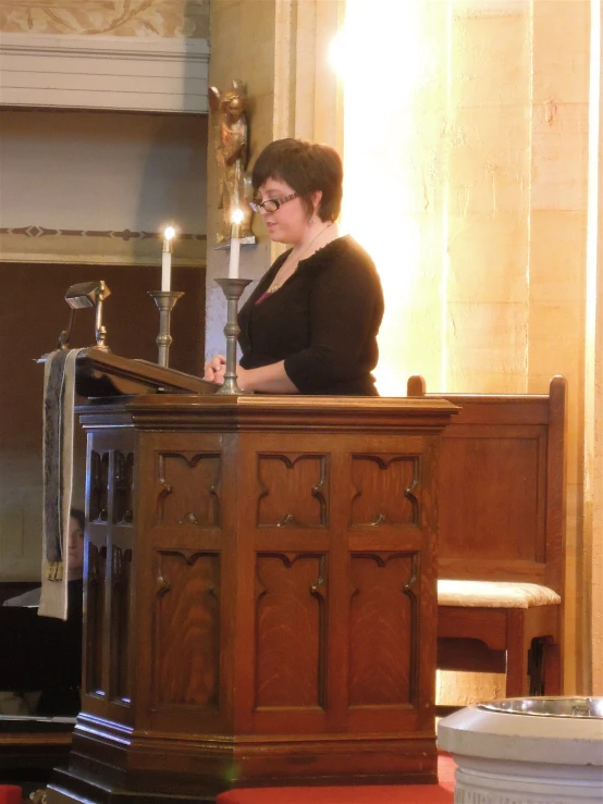 the lady is sitting at the alter reading her holy book