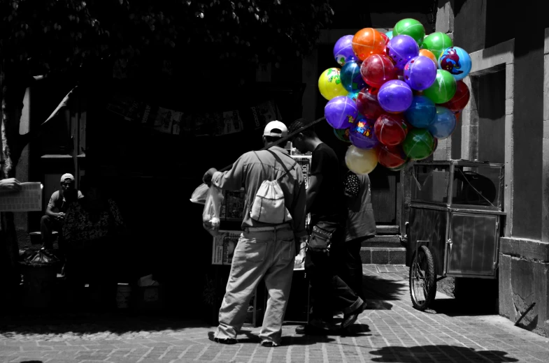 a person standing with a bunch of balloons