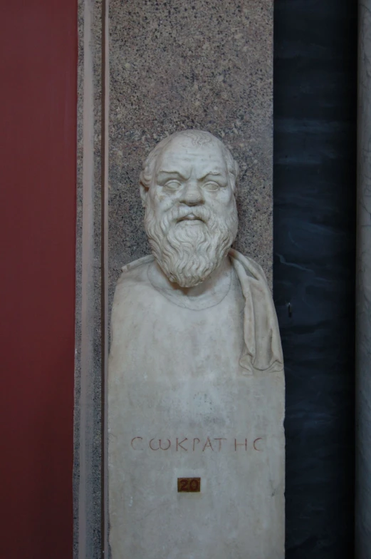 a busture of an old man sitting in a building