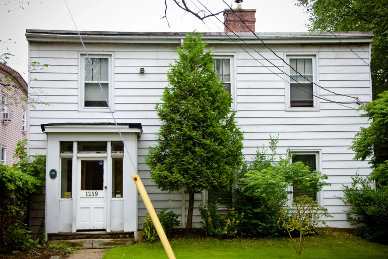 a house and tree are behind a fence