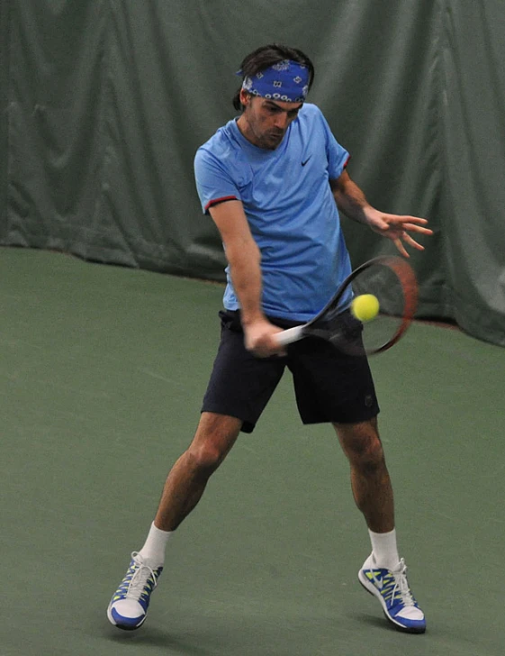 a man swinging at a tennis ball with a racquet