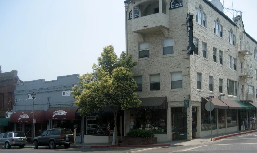 an old white brick building sits empty on a corner