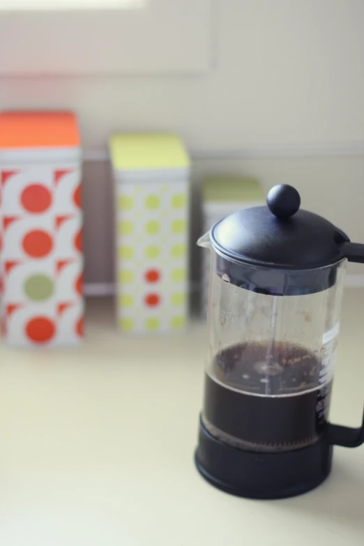 the glass blender has a black lid and is set on a counter