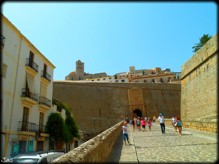 some people are walking on a walkway in an old city