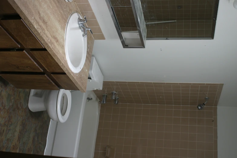 a bathroom with brown tile walls and brown flooring