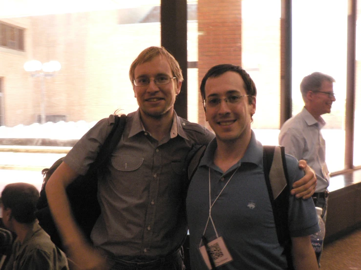 two men standing next to each other with backpacks on