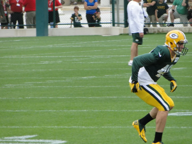 a man with yellow and green football uniforms in the grass