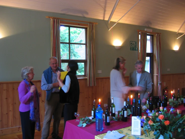 people standing and clapping with many bottles of wine