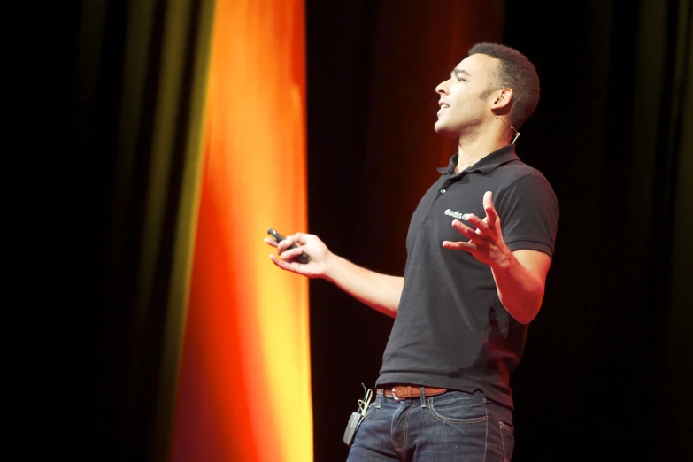 the man is standing in front of an orange and green wall