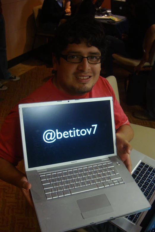 a man holding a laptop with the word below the screen