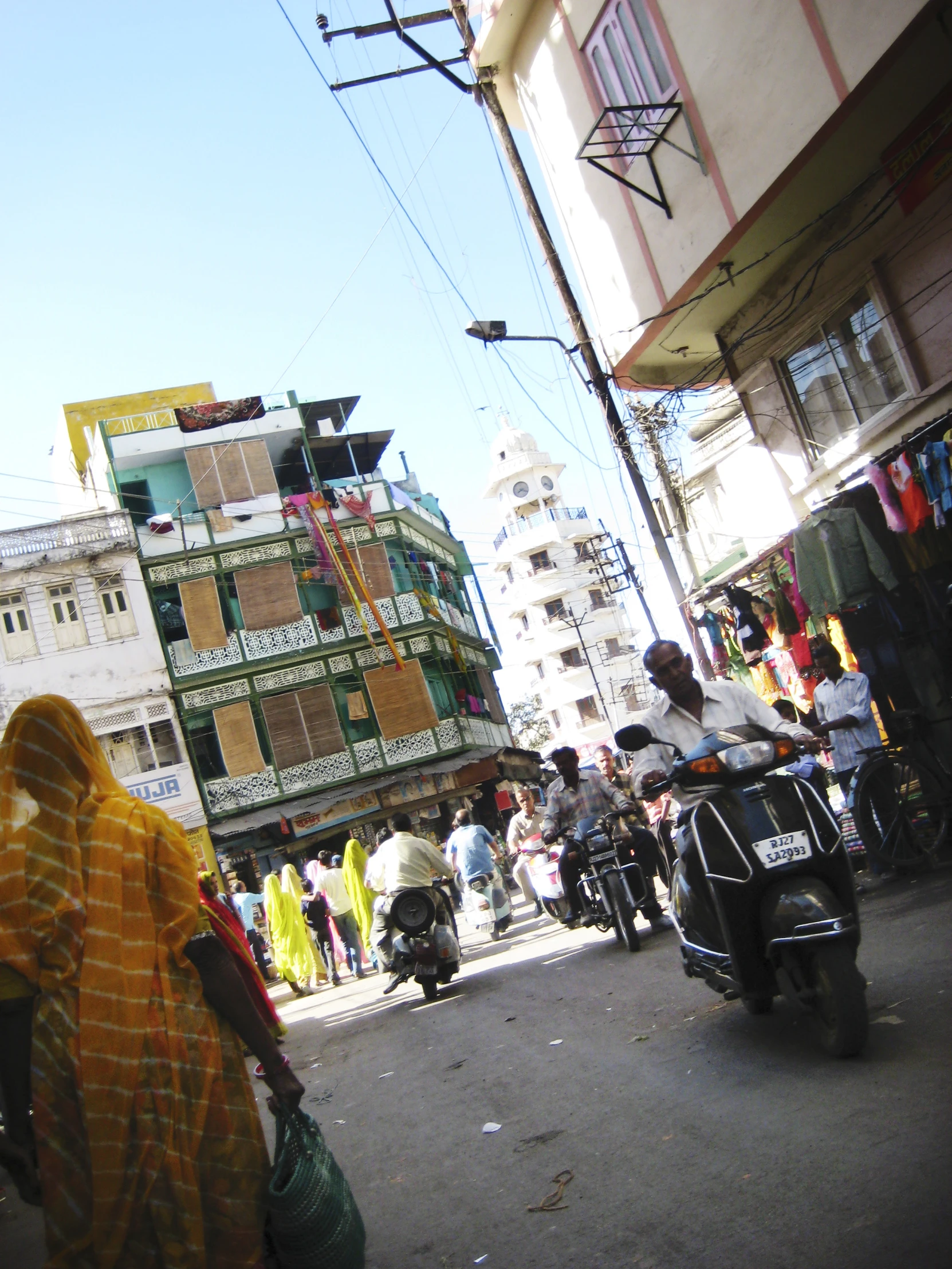 motorcycle riding down a street with multiple buildings