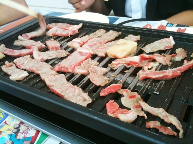 a grill with steaks and food on it