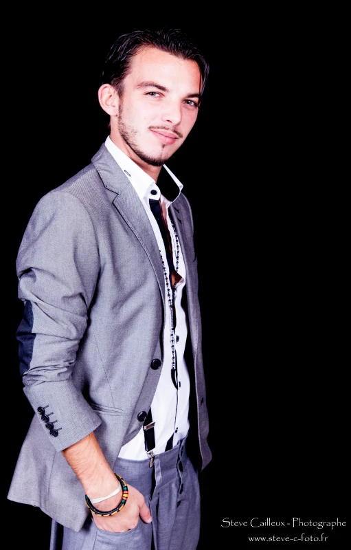 an attractive young man in a suit and tie posing for the camera