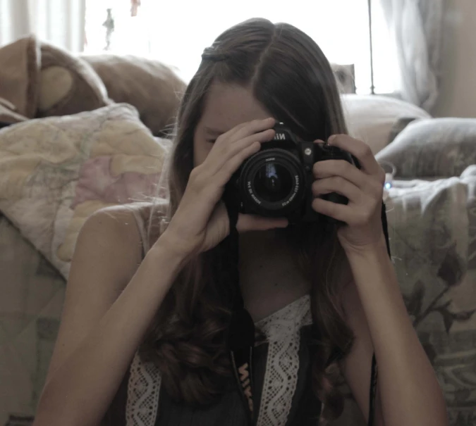 a woman that is holding a camera in front of her face