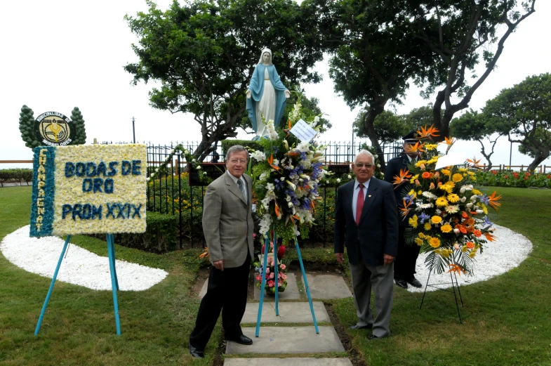 two men standing by a memorial in a park