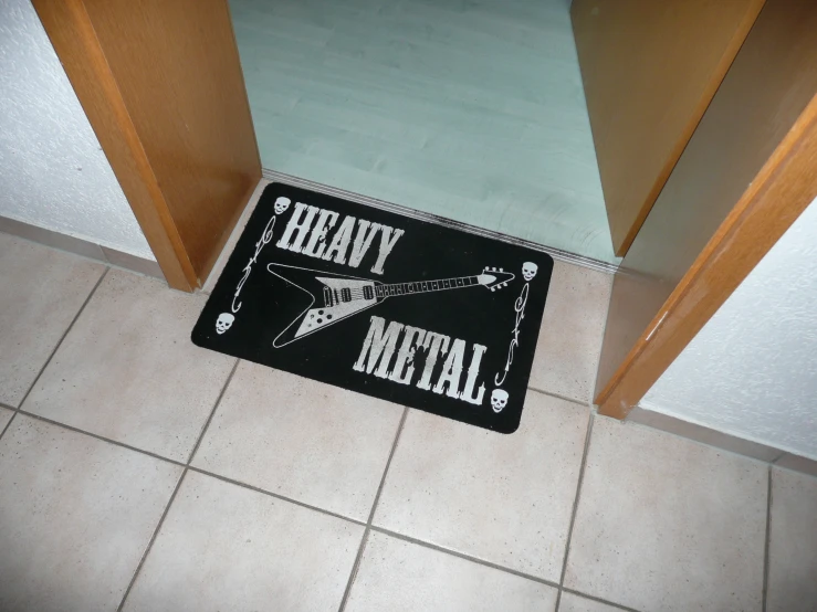 a black mat with a guitar on it sitting next to brown cabinets