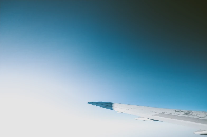 wing of airplane with blue sky in the background