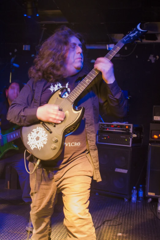 man playing an electric guitar with three microphones