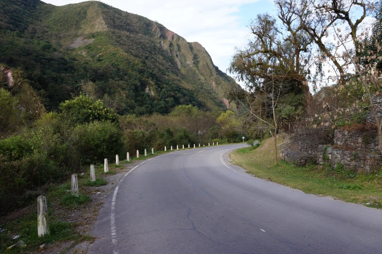 a curved road winding down into a green valley