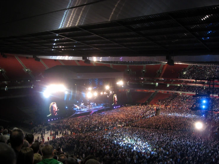 large crowd in arena watching band on stage