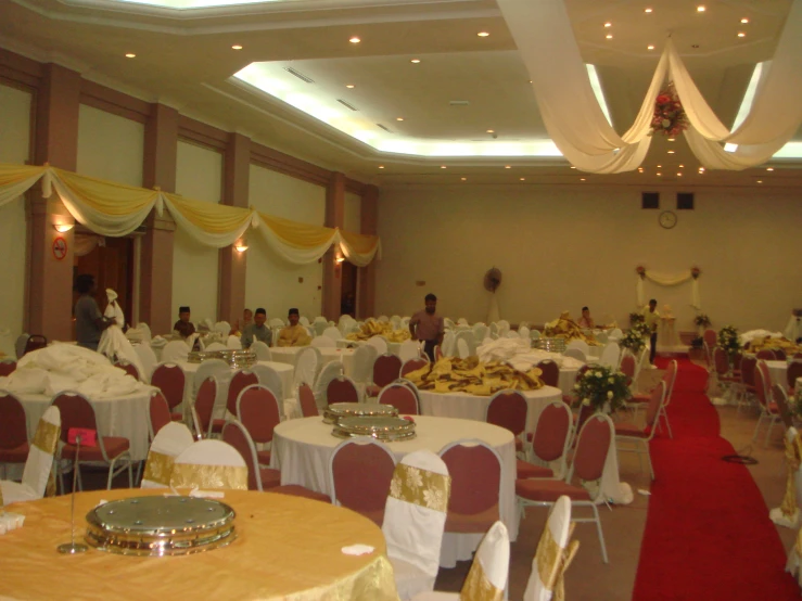 a room with many tables and chairs filled with food