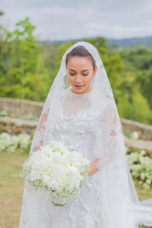 a beautiful young bride poses for a pograph