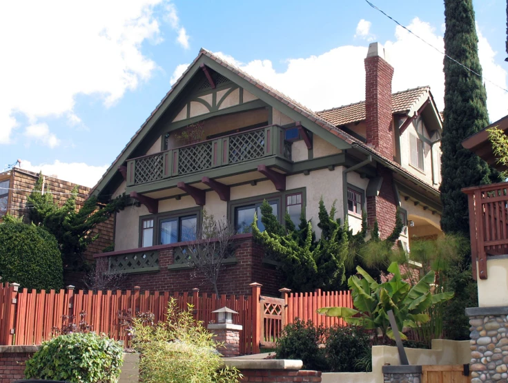 a red and white house with a tall wood fence