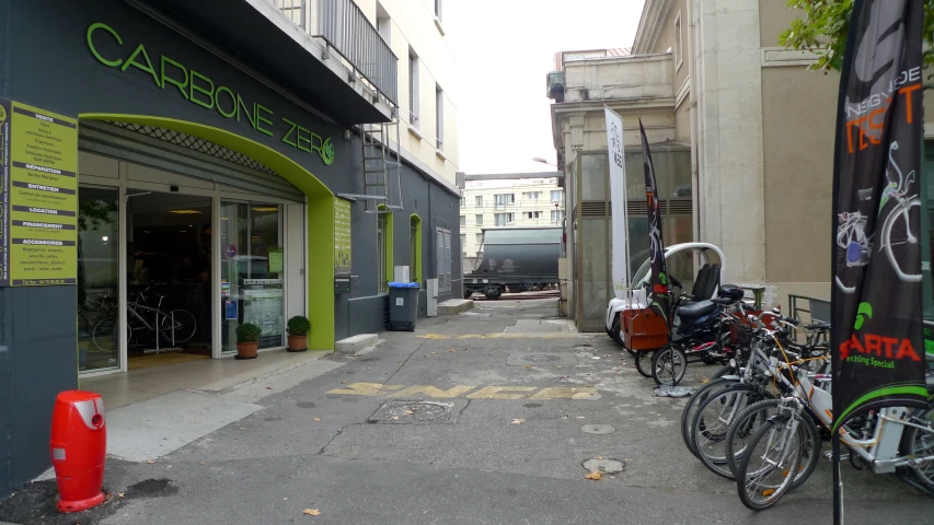 a row of parked bicycles are in front of a green and white business