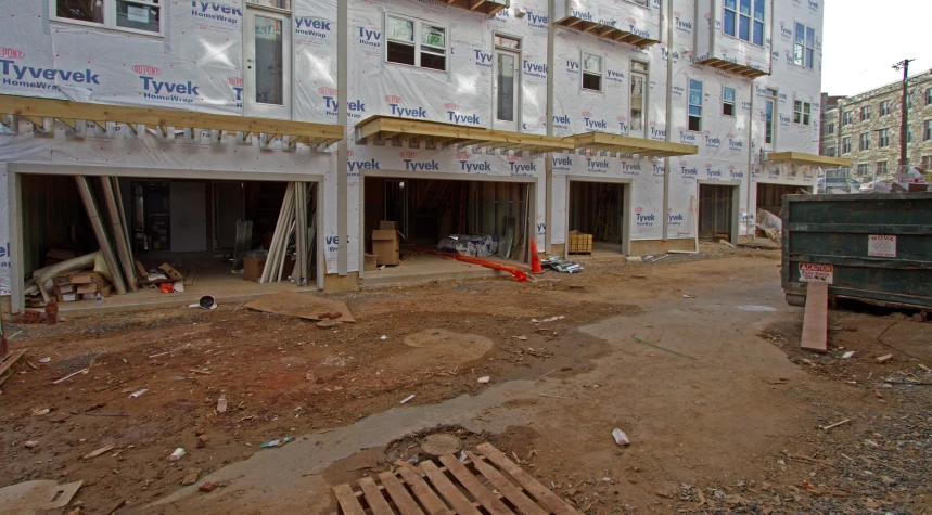 a large building under construction and a dumpster behind it