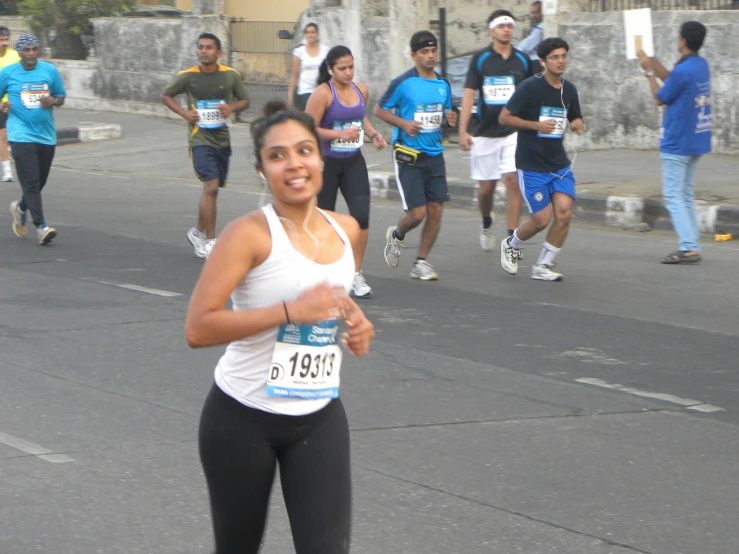 a woman in black pants running in a marathon