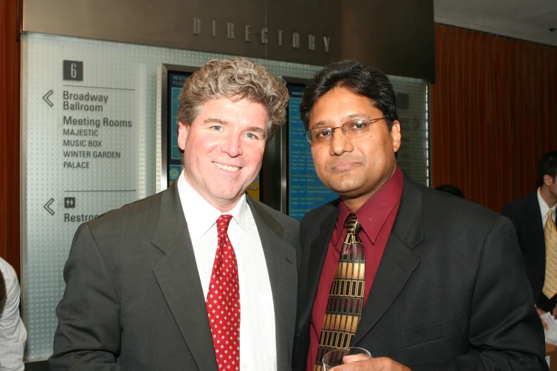 two businessmen with ties smiling for the camera