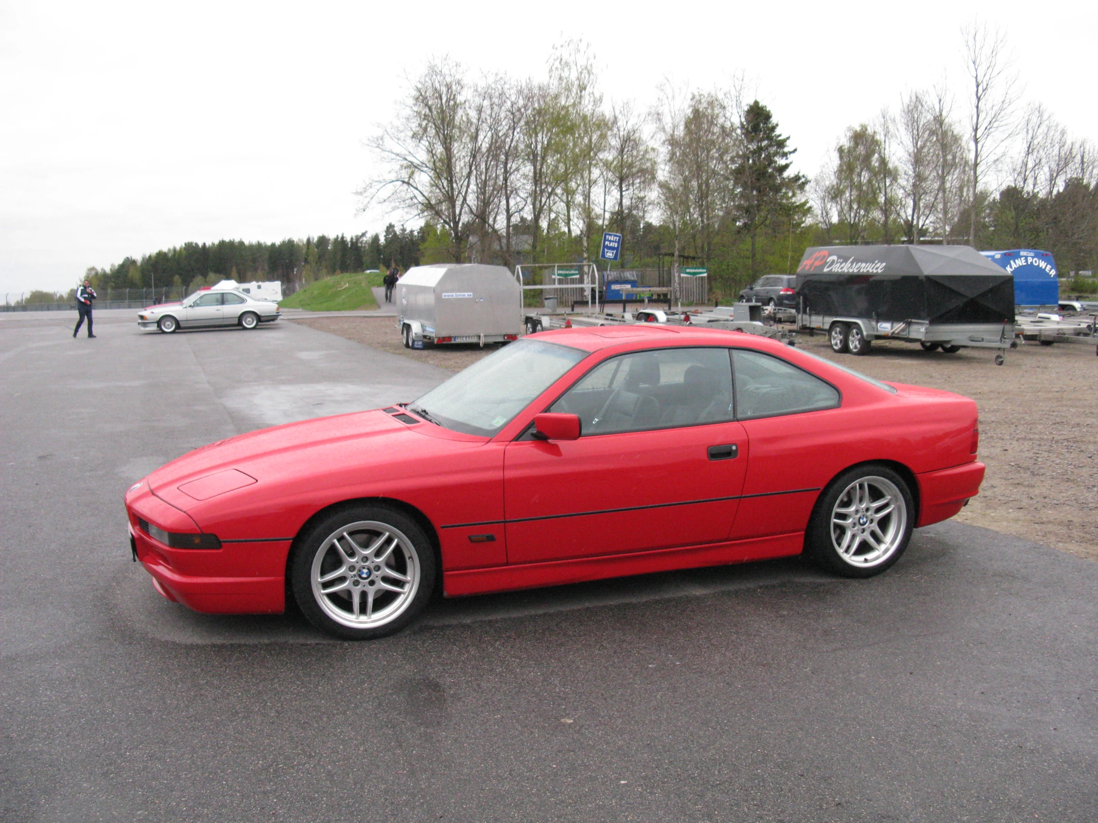 red sports car is parked in a parking lot