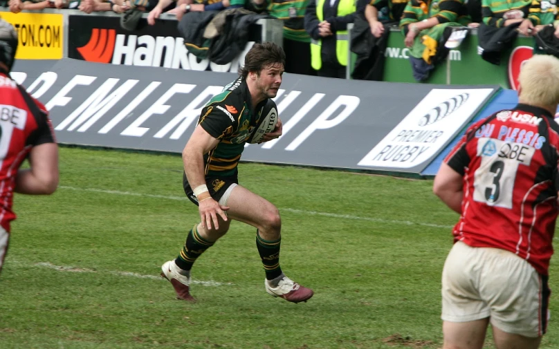 a rugby player is on his knees as he runs for the ball