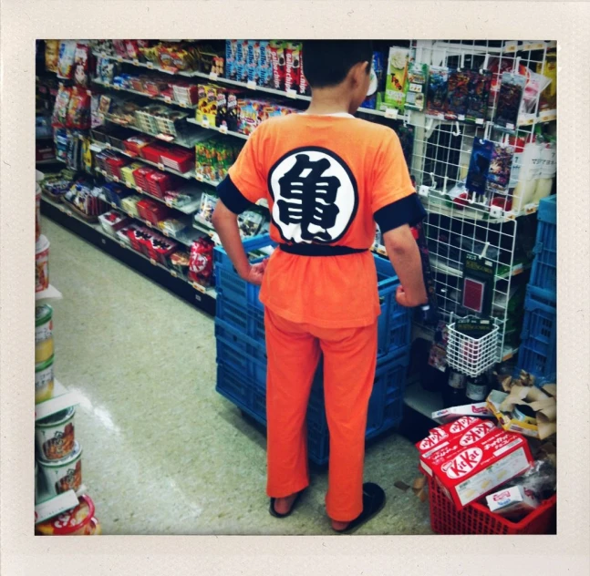 a man in an orange shirt is standing in a store