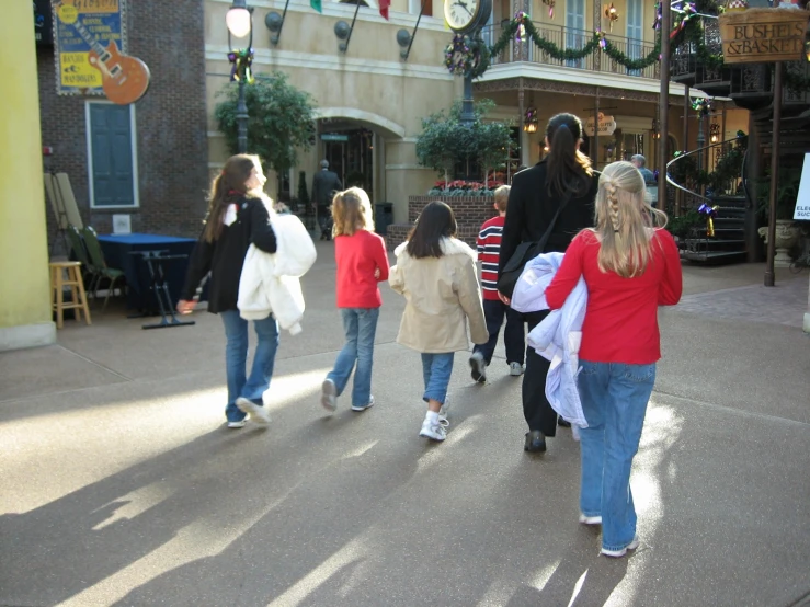 children and adult walking down the street with shopping carts