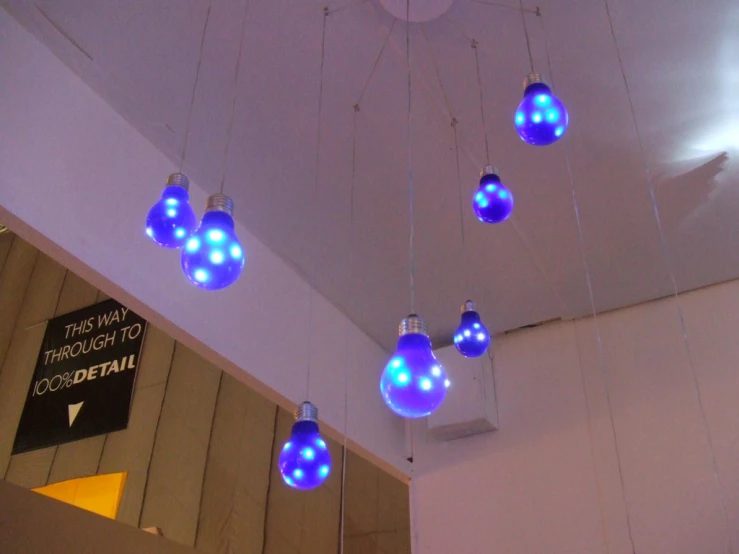 blue light bulbs suspended from a ceiling of an empty hall
