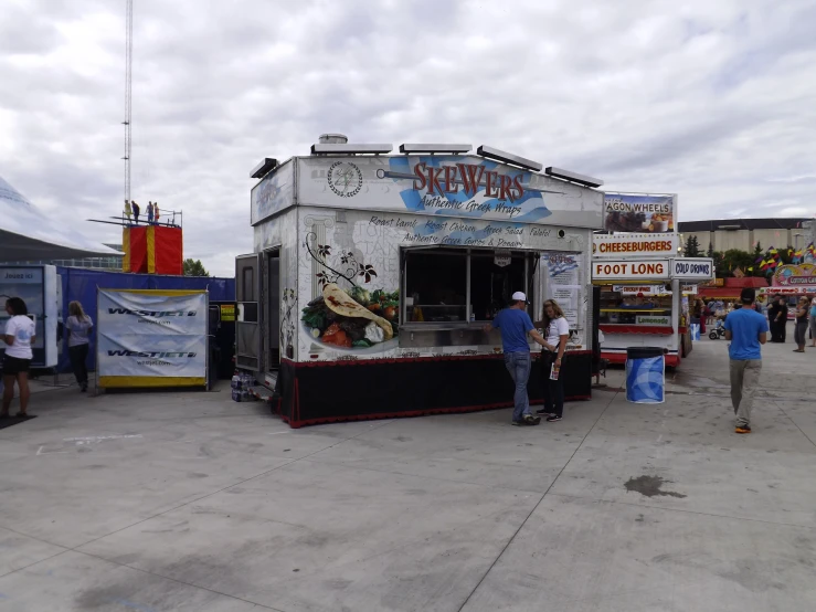 the food stand is located with a wide variety of people