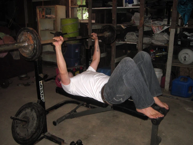 a man sitting on the bench with weights in the background