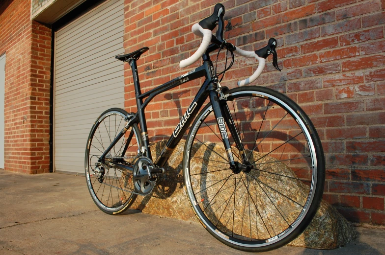 a bicycle parked next to a wall on the street